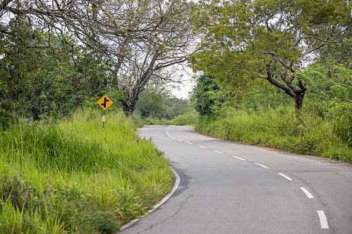 Road sign telling there is small adjacent side roads on road through the lush landscape in the North Central Province in Sri Lanka