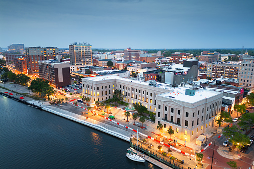 Wilmington, North Carolina, USA cityscape over the Cape Fear and Wilmington Riverwalk at dusk.