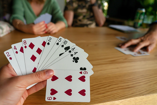 Close-up of a person playing cards at bar