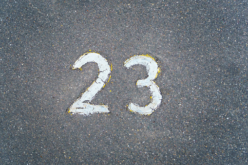 The number 23 written in white paint on the asphalt