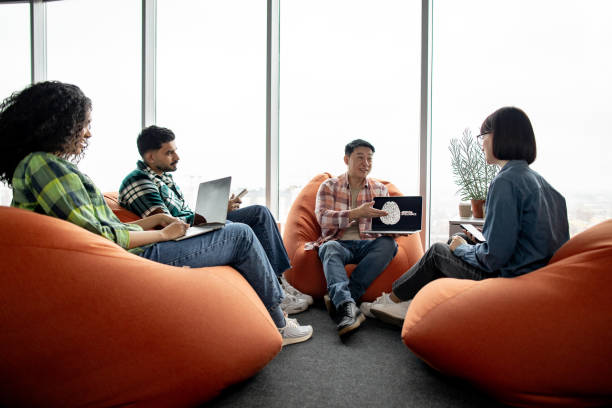 istock Male with AI project on laptop chatting with teammates 1489795912