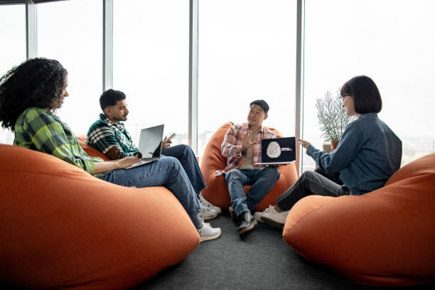 istock Male with AI project on laptop chatting with teammates 1489795916