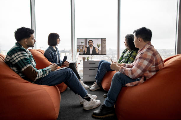 istock Employees making video call on display in office interior 1489797518