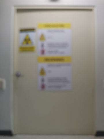 Xray room door with warning signs blurred background