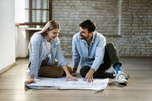 istock Young couple analyzing housing plan in their new home 1489798676