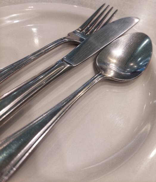 istock Stainless steel cutlery on beige plate 1489800505