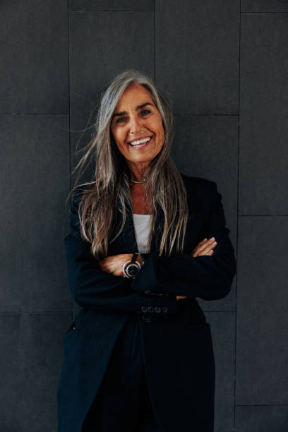 istock Smiling senior  businesswoman on dark background with copy-space. 1489800973