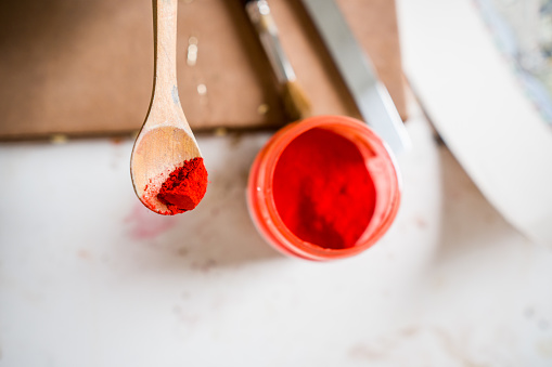 red pigment in a wooden spoon