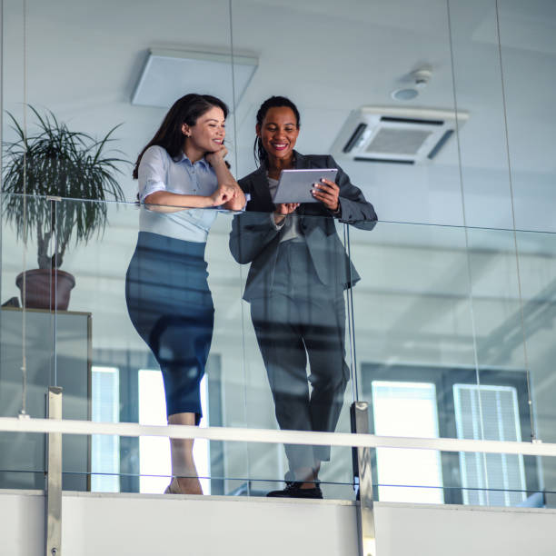 istock Business people leaning against a glass fence and using a digital tablet 1489805635