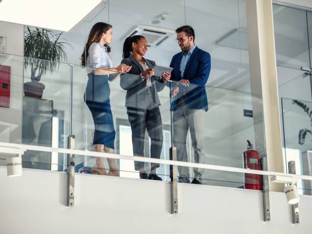 istock Business people leaning against a glass fence and using a digital tablet 1489805920