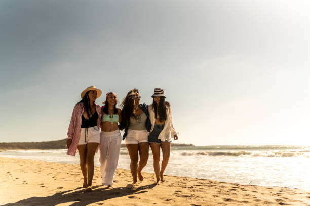 istock Female friends embracing while walking on the beach 1489806831