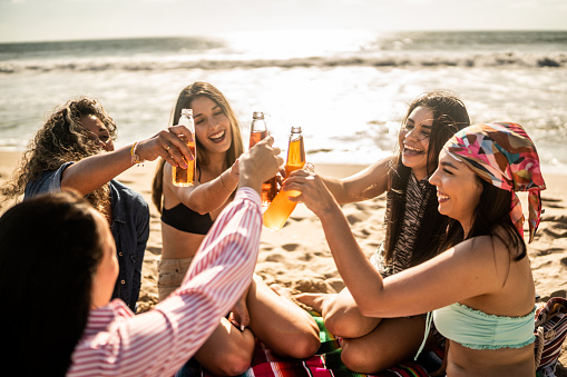 Female friends celebration doing a celebratory toast on the beach