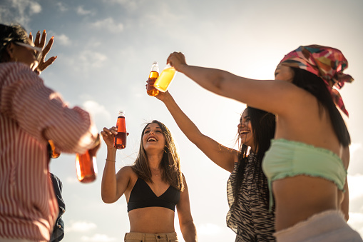 Female friends celebration doing a celebratory toast on the beach
