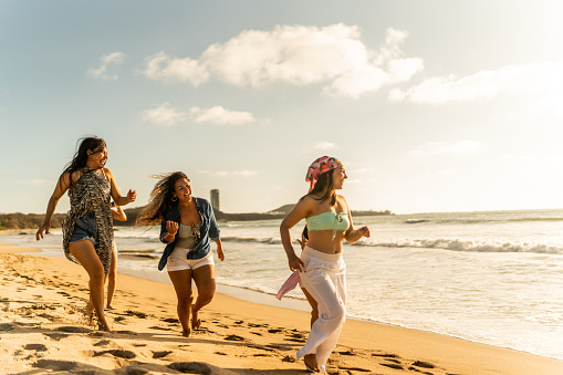 Female friends having fun while walking on the beach