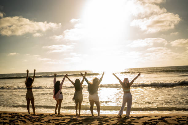 istock Females friends enjoying sunset on the beach 1489808004