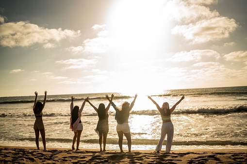 Females friends enjoying sunset on the beach