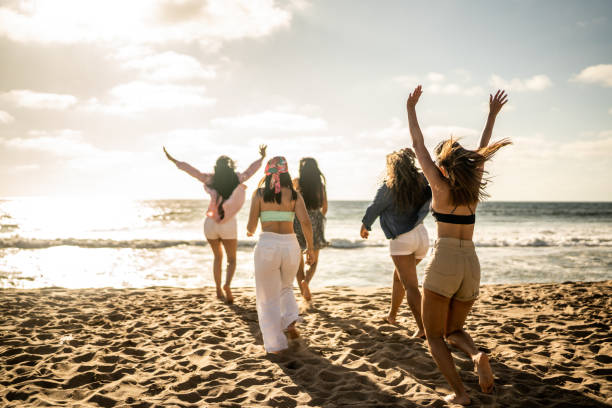 istock Female friends having fun while walking on the beach 1489808248