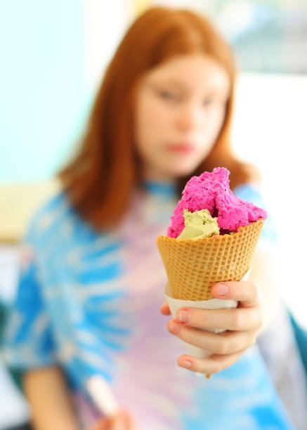 istock girl holds an ice cream cone in close-up 1489810008
