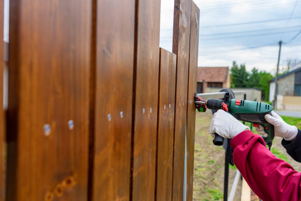 un homme construit sa propre clôture en bois spéciale avec foreur - fence photos et images de collection