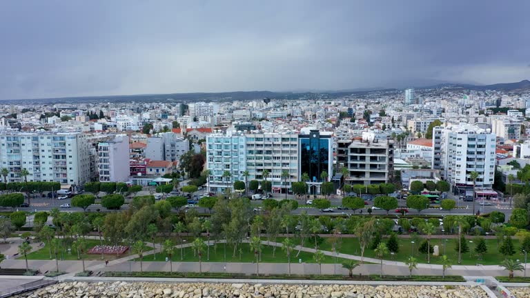 Aerial view of Molos Promenade park on coast of Limassol, Cyprus. Limassol promenade or embankment at sunset. Aerial view of famous Cyprus alley with palms and walking people, Limassol, Cyprus.