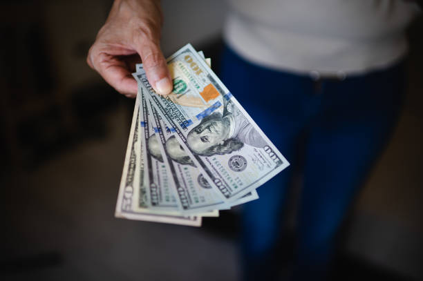istock Man hand with a stack of US dollars bills 1489815939