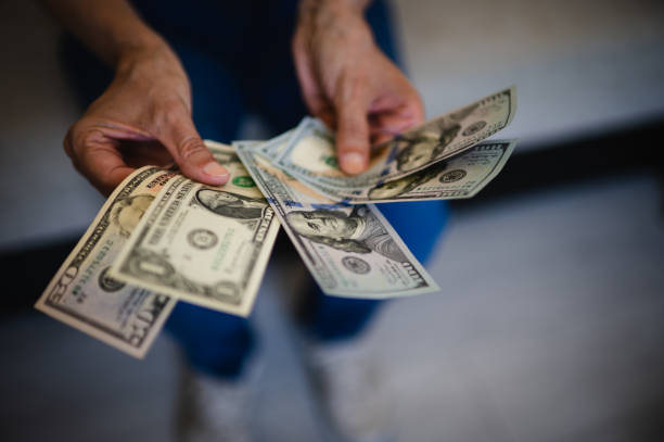 istock Man hand with a stack of US dollars bills 1489815988
