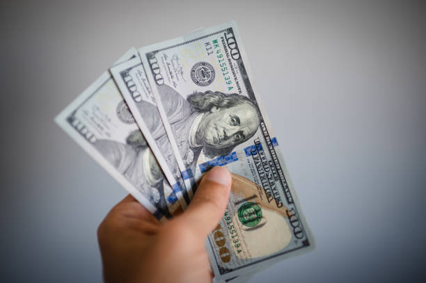 istock Man hand with a stack of US dollars bills 1489816001