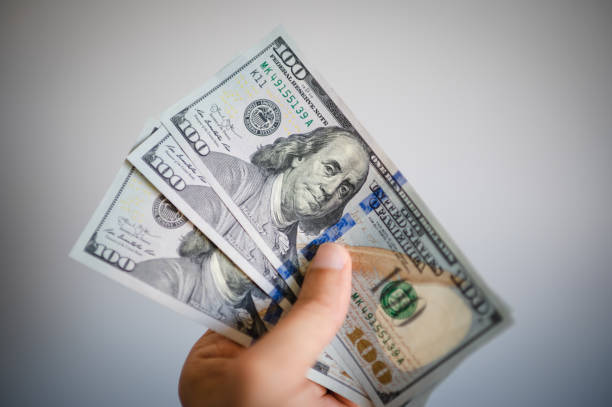 istock Man hand with a stack of US dollars bills 1489816011