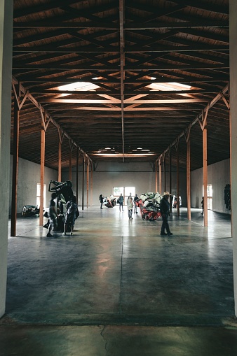 Marfa, United States – June 15, 2012: Inside a spacious garage, with several individuals walking and interacting with one another