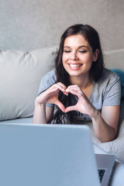 istock Young woman using a laptop to connect with her friends and parents during quarantine 1489824997