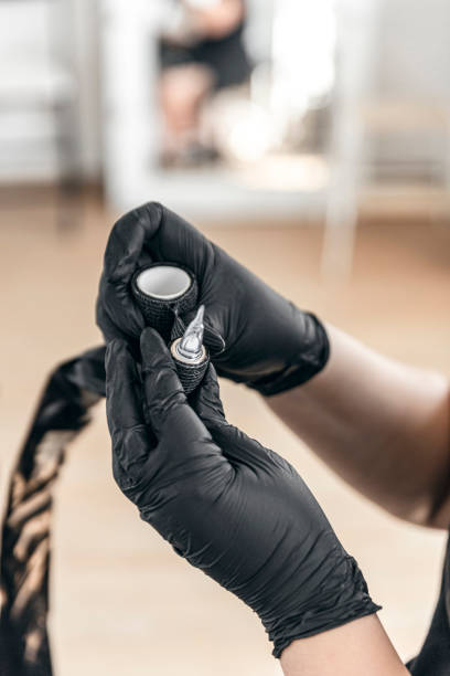 istock Unrecognizable person artist preparing tattoo machine before making a tattoo 1489825083