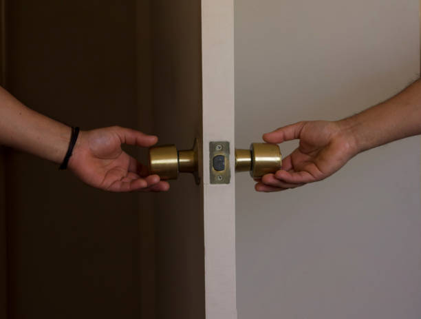 istock people's hands, opening a door at the same time. 1489829901