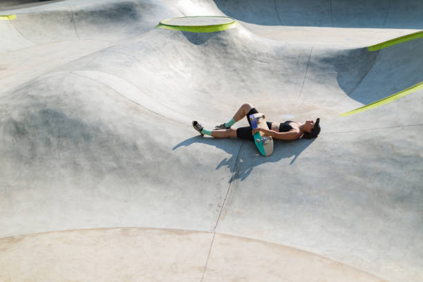 istock Young woman with skateboard resting in skate park 1489832283