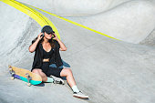 Young adult woman in skate park listening to music