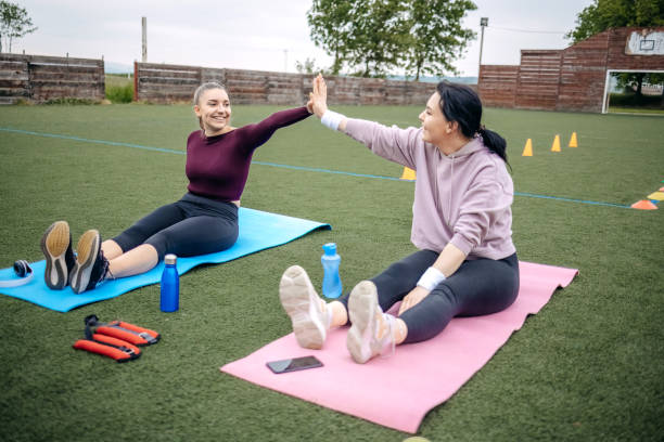 young woman exercising outdoors. - playing field effort outdoors human age imagens e fotografias de stock