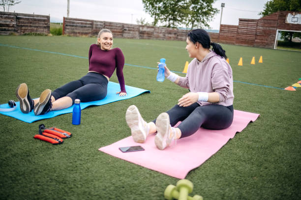 young woman exercising outdoors. - playing field effort outdoors human age imagens e fotografias de stock