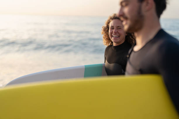 Happy woman with her male surf instructor ready for the surf lesson stock photo