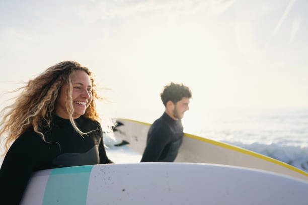 istock Couple surfers running on the beach with their surfboards 1489850081