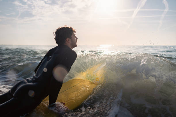 istock Unrecognizable male surfer trying to catch a wave 1489850393