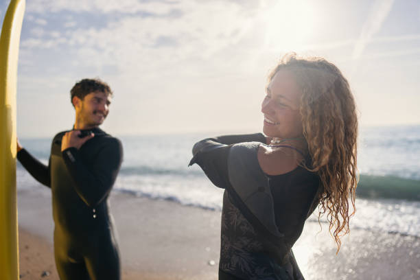 istock Young Caucasian female surfer, adjusting her wet suit 1489850434