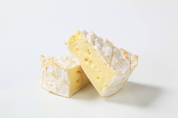 camembert cheese two triangular pieces of a ripe camembert cheese brie stock pictures, royalty-free photos & images
