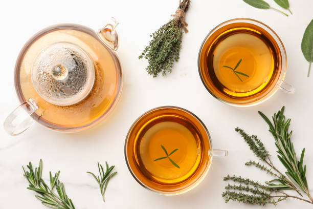 istock Aromatic herbal tea with thyme, rosemary and sage on white marble table, flat lay 1489867404