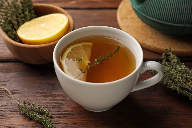 istock Aromatic herbal tea with thyme and lemon on wooden table 1489867581