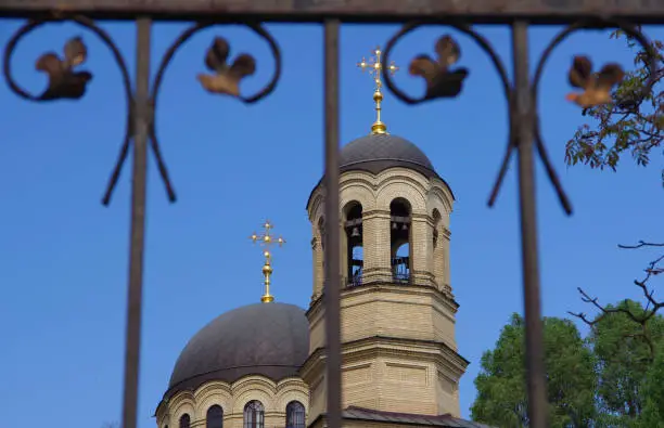 View of the temple through the fence against the blue sky.