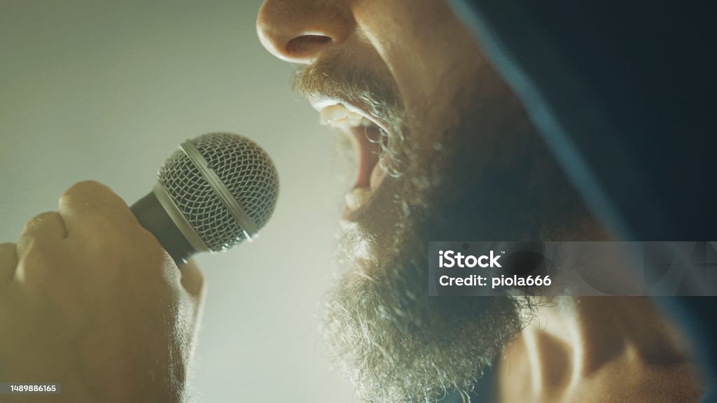 Rock singer screaming in a live show with stage lights Live Event Stock Photo