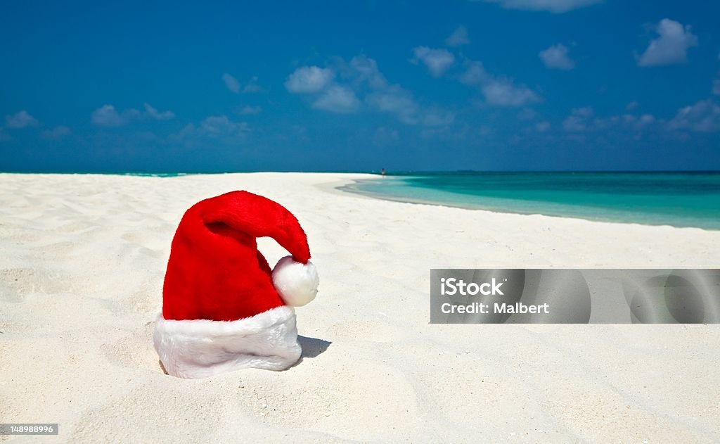 Santa hat is on a beach Santa hat is on infinity coral sandy beach Adult Stock Photo