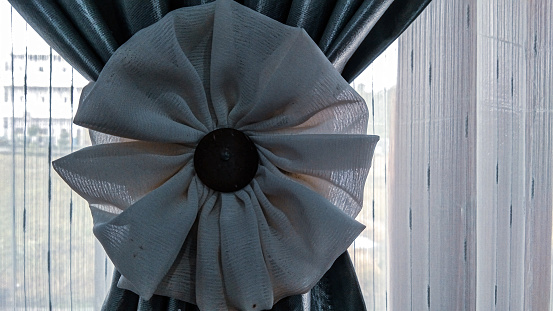 a large flower decoration to beautify the curtains attached to the window
