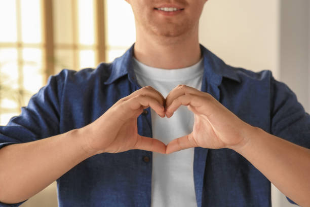 istock Man making heart with hands indoors, closeup. Volunteer concept 1489904893