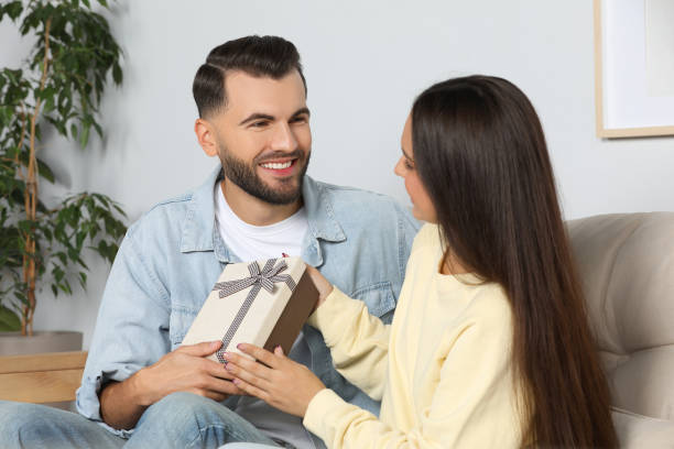 istock Lovely couple with beautiful gift at home 1489905284