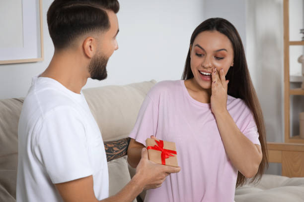istock Man presenting gift to his girlfriend at home 1489905412